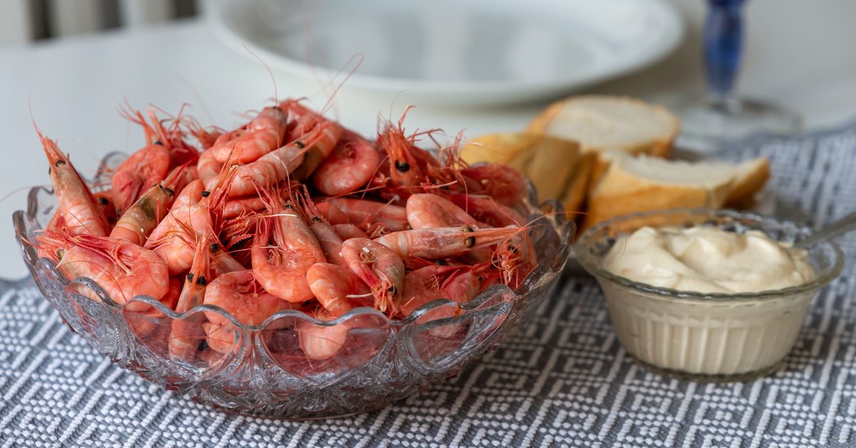Bol de crevettes roses cuites servies avec du pain et une mayonnaise
